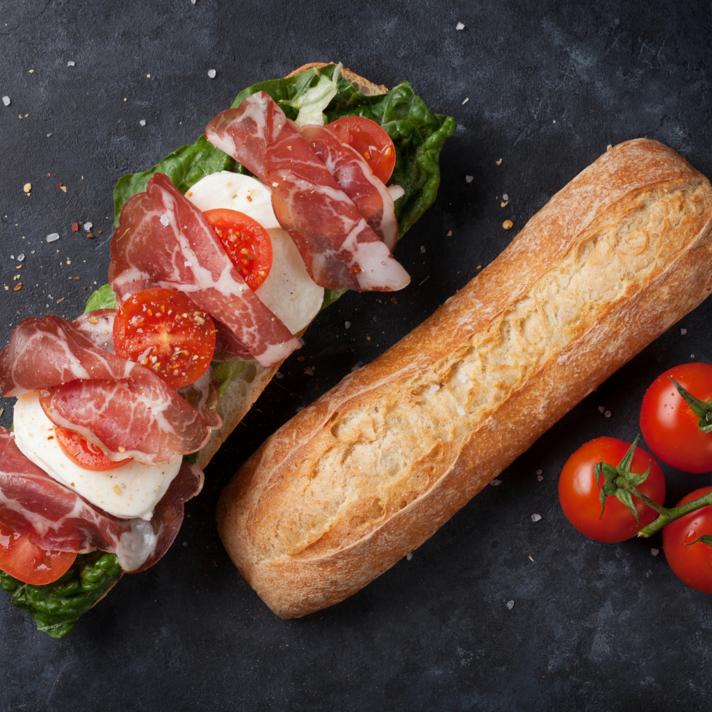 Бутерброд с ветчиной, помидорами, яйцом и листьями салата