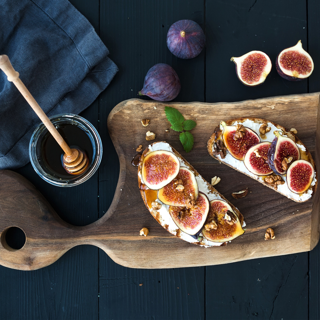 Бутерброды с инжиром на разделочной доске с медом 