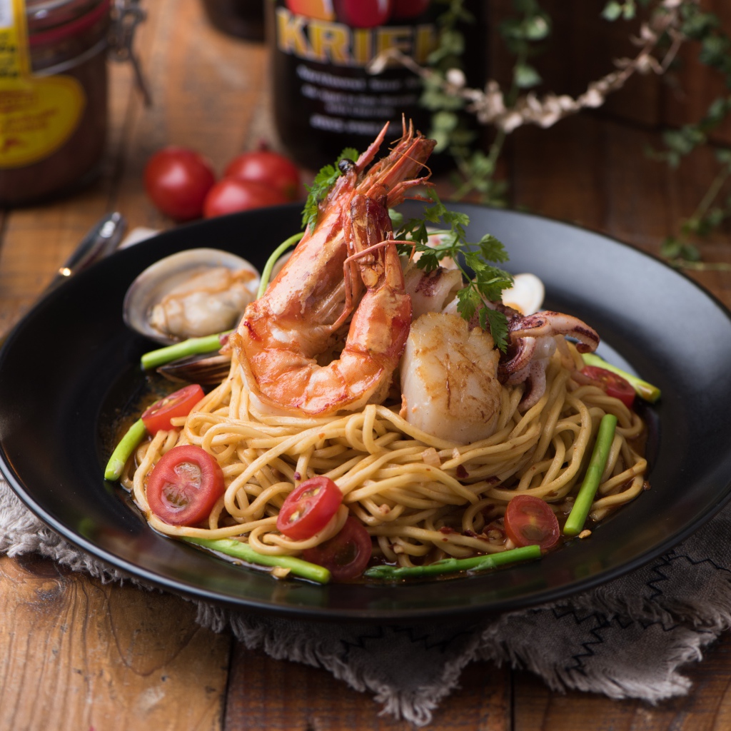Спагетти с морепродуктами на черной тарелке