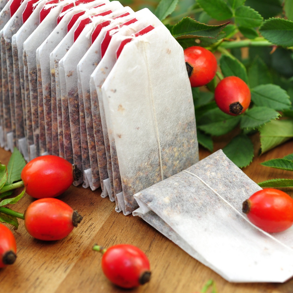 Чай в пакетиках на столе с ягодами шиповника 