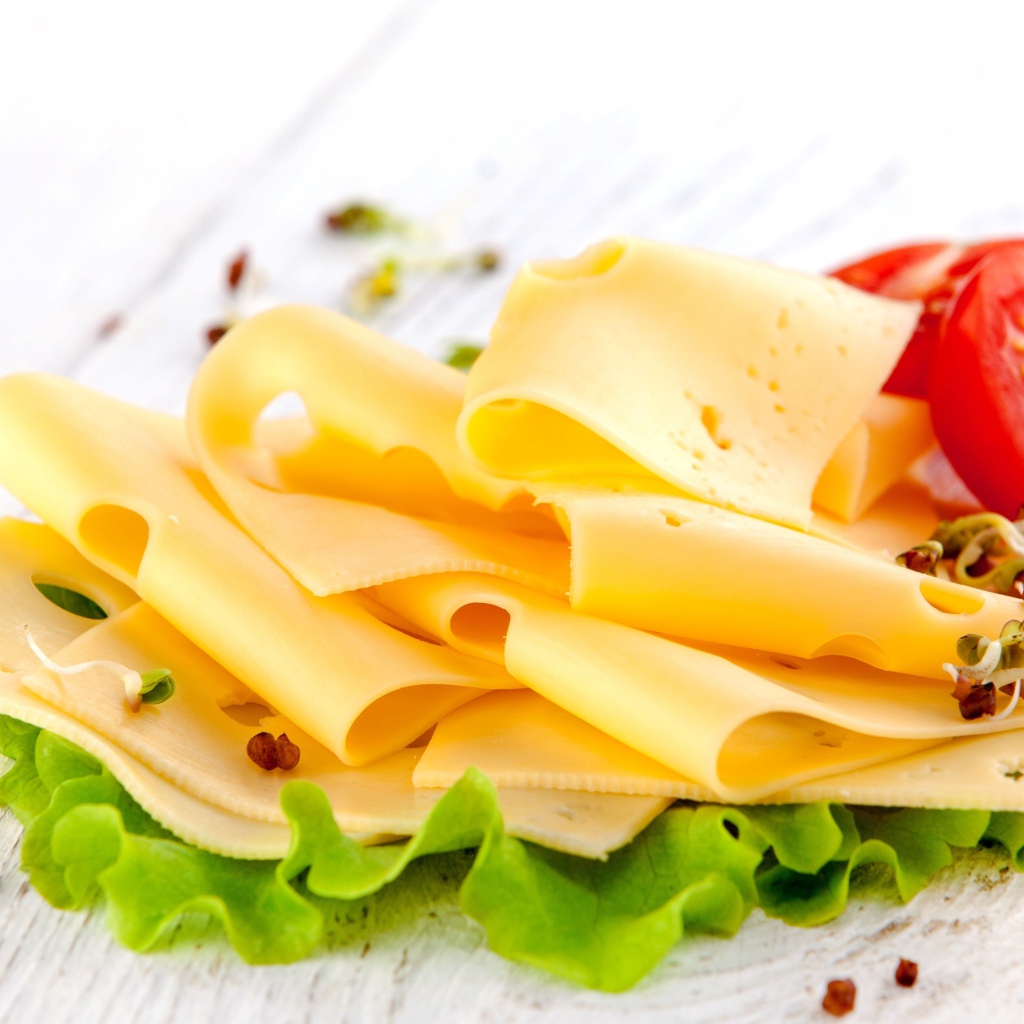 Тонко нарезанный сыр с листом салата и помидором