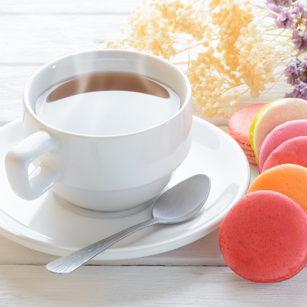 Белая чашка чая с макарунами