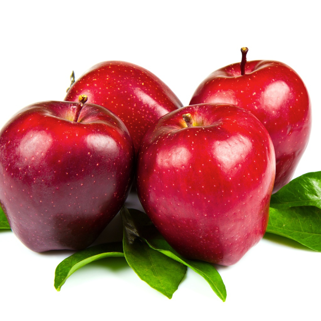 Красивые красные яблоки с зелеными листьями на белом фоне