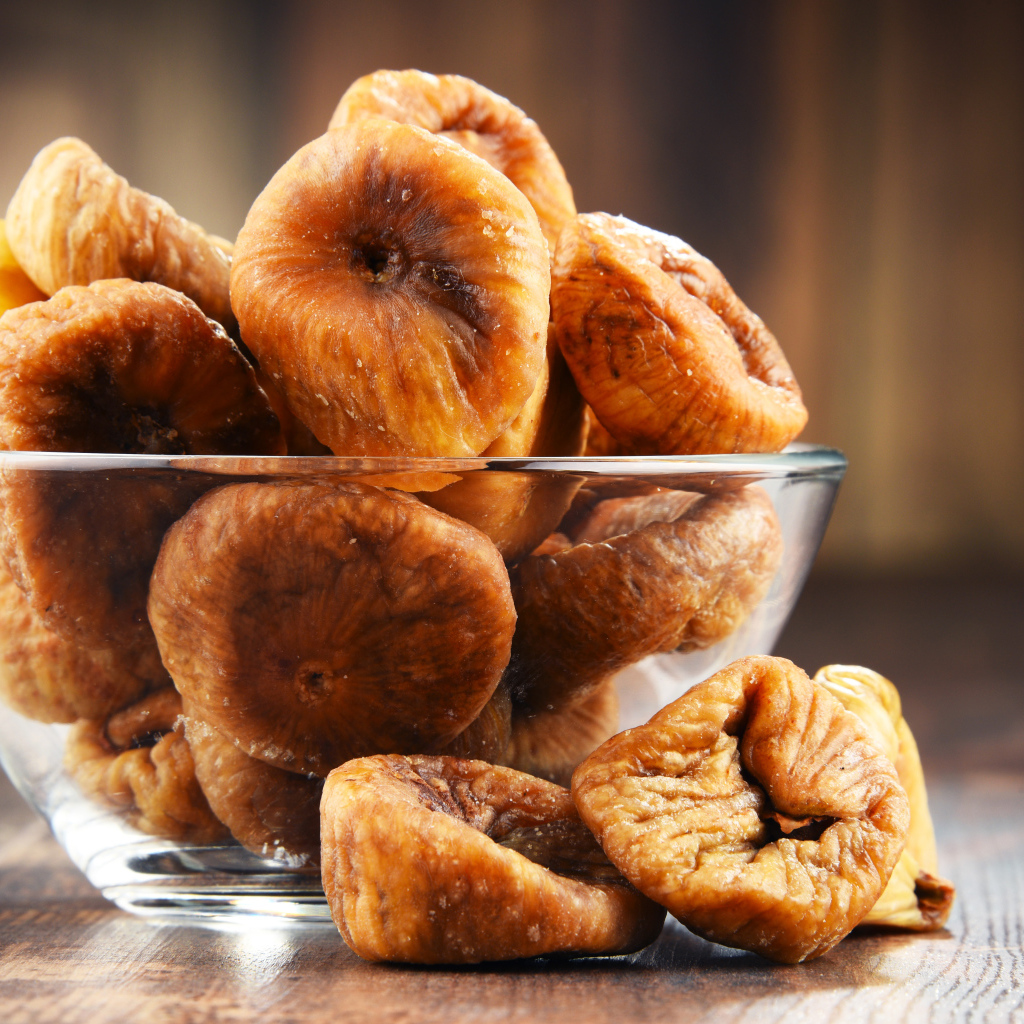 Инжир в стеклянной вазе на столе 