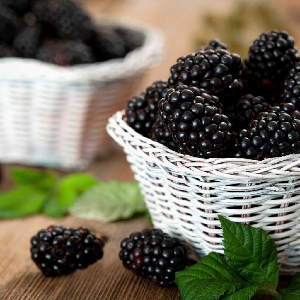 Свежые ягоды ежевики в белой корзинке на столе