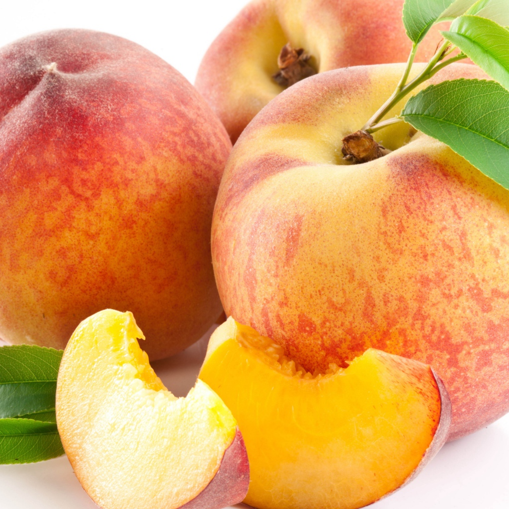Крупные спелые сладкие персики на белом фоне