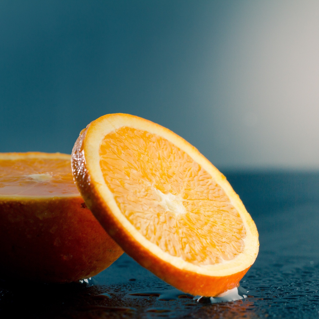 Оранжевый апельсин на мокром столе