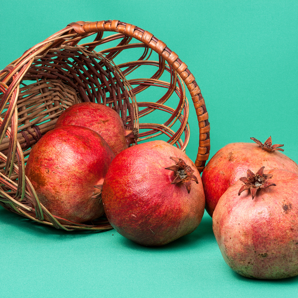 Плоды граната в корзине на голубом фоне
