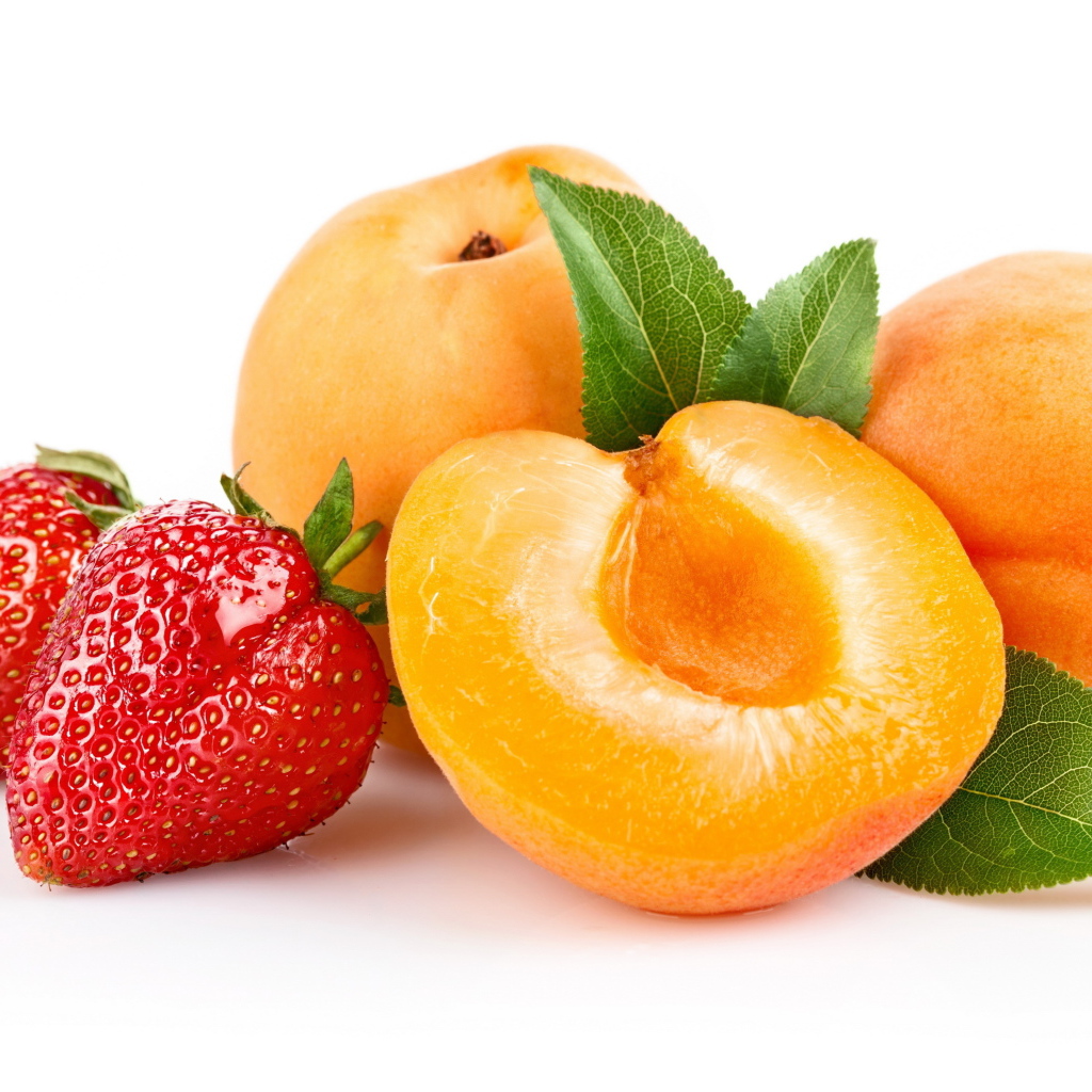 Спелые абрикосы с ягодами клубники на белом фоне