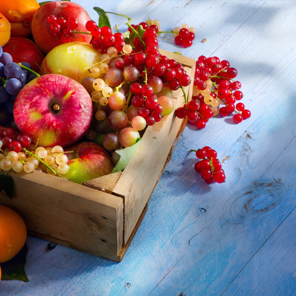 Спелые сочные ягоды и фрукты на столе в деревянном ящике