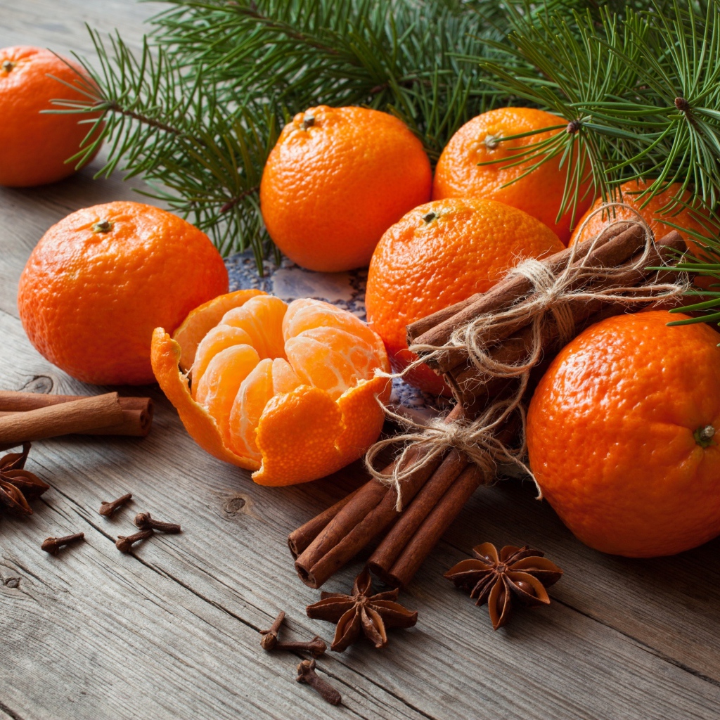 Вкусные спелые мандарины с корицей и бадьяном на столе с еловой веткой