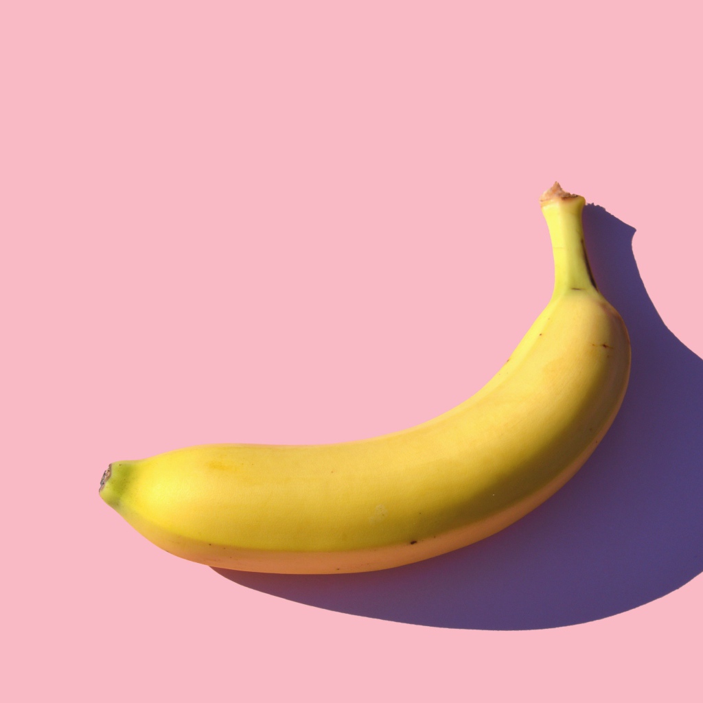 Желтый банан на розовом фоне