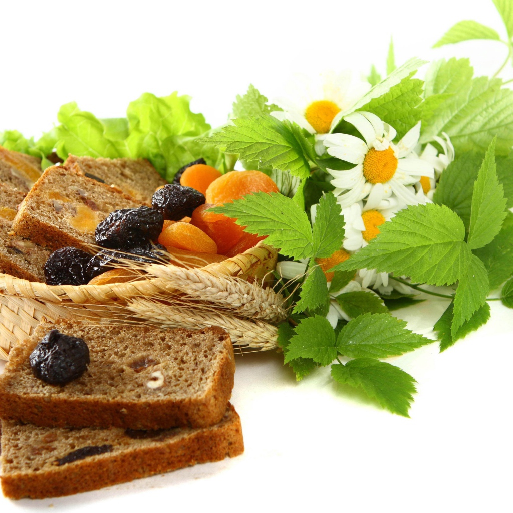 Сухофрукты с хлебом и цветами ромашки на белом фоне