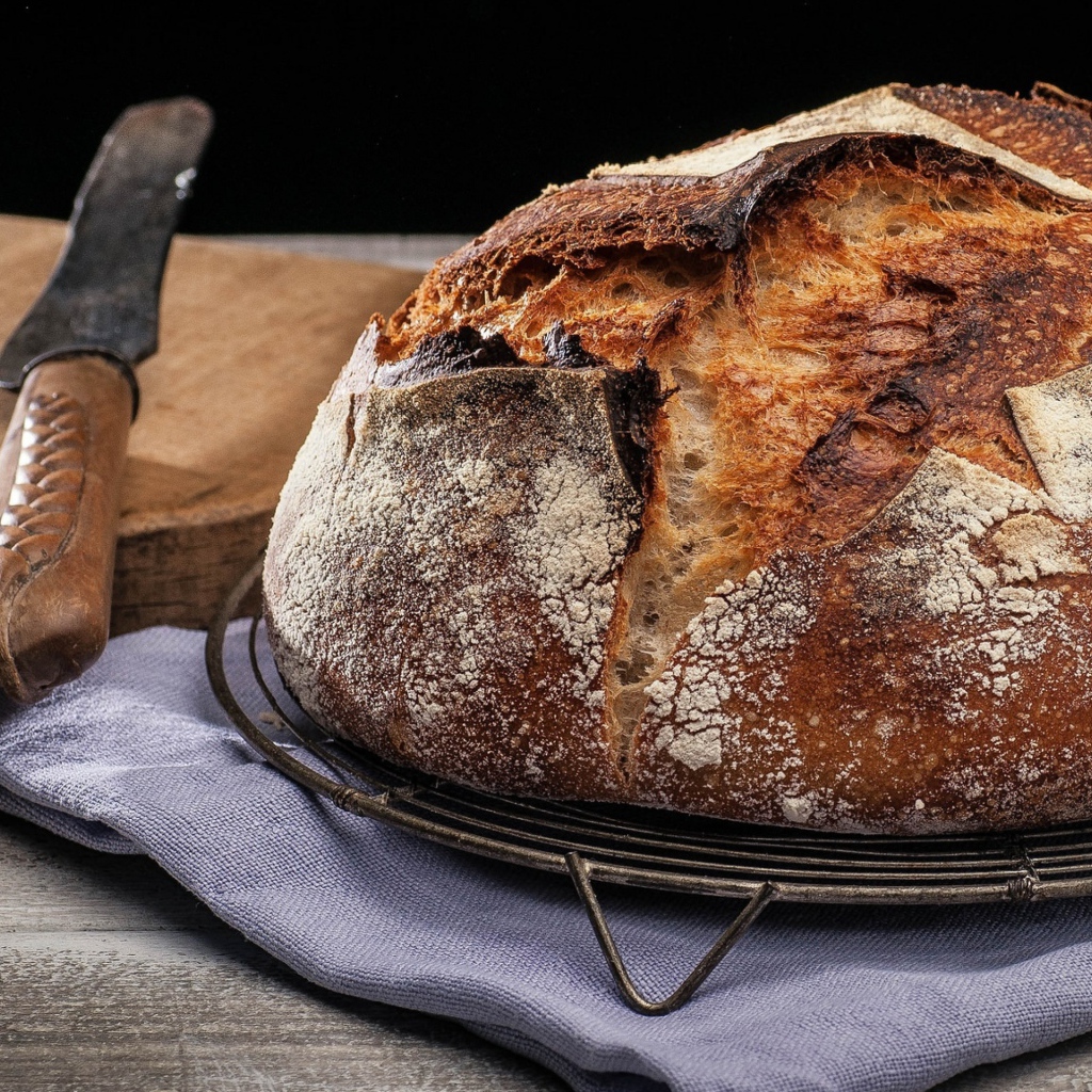 Зажареный круглый хлеб на столе с ножом