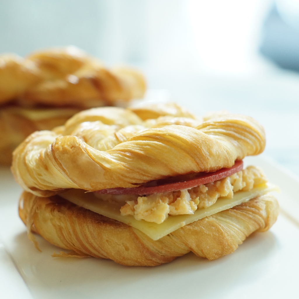 Две булочки с сыром и колбасой на столе