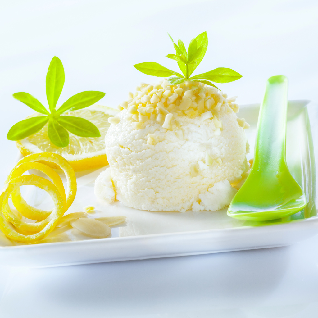 Шарик лимонного мороженого с фисташками с зеленой ложкой