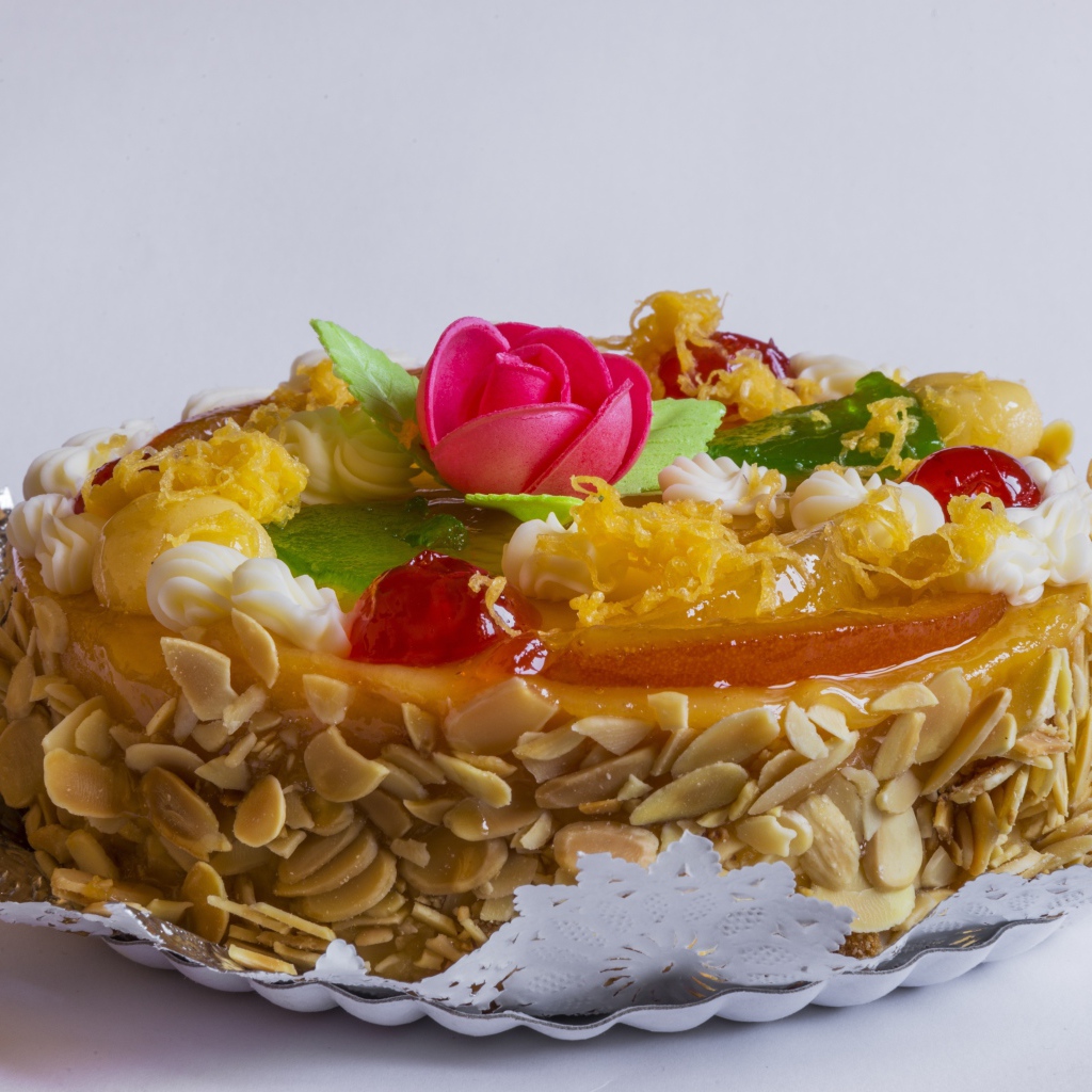 Красивый торт с кремом и ягодами украшен розовым цветком