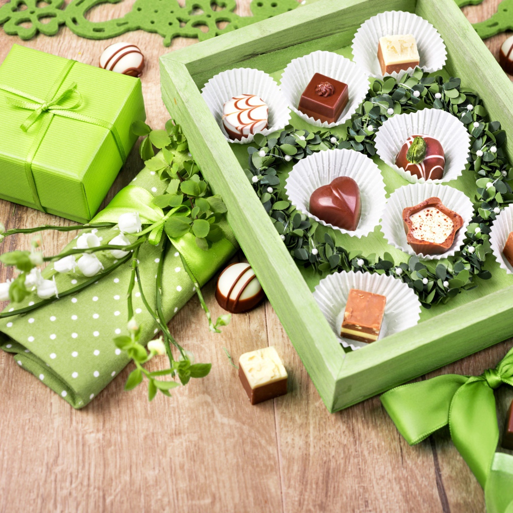 Коробка шоколадных конфет с подарком на столе