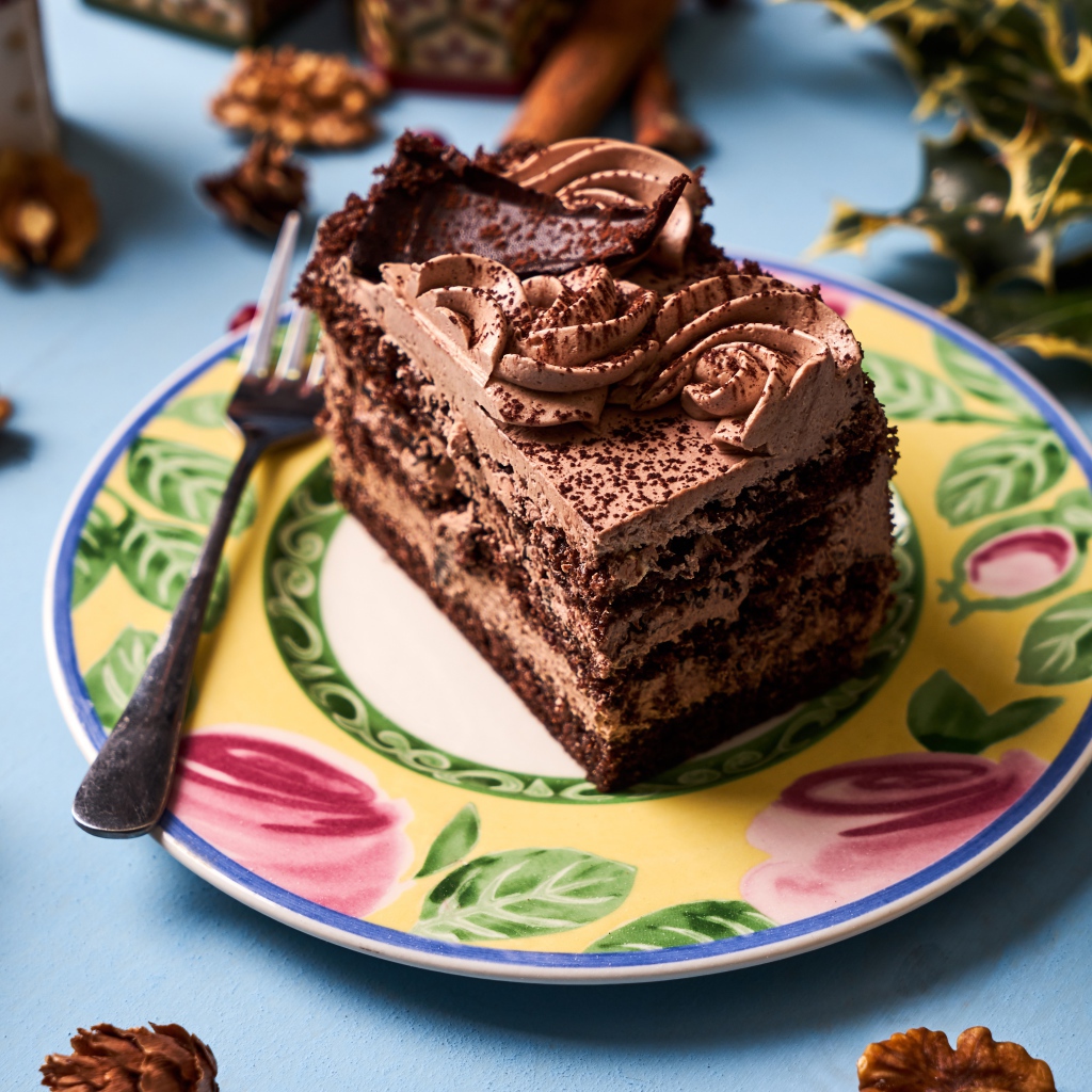 Кусок торта с кремом и шоколадом на тарелке 