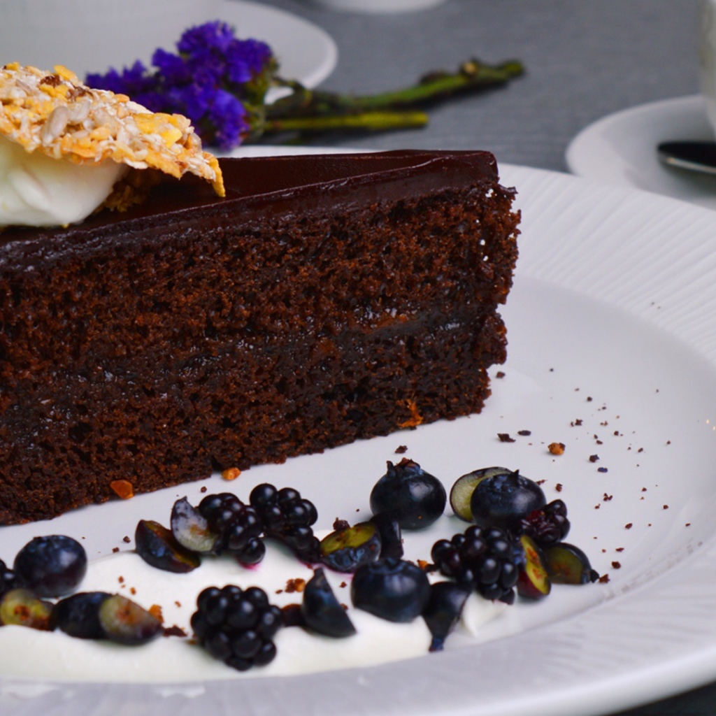 Кусок шоколадного пирога на большой белой тарелке