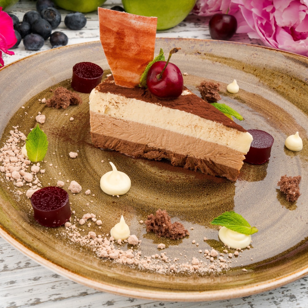 Кусок торта три шоколада на блюде 