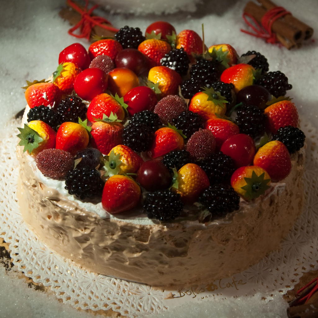 Аппетитный торт с ягодами на столе 