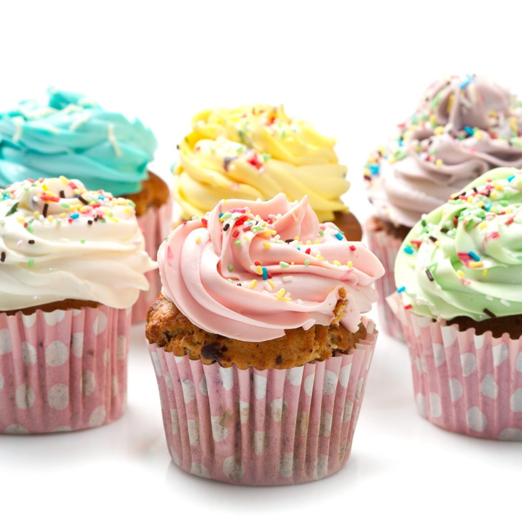 Аппетитные капкейки с кремом на белом фоне
