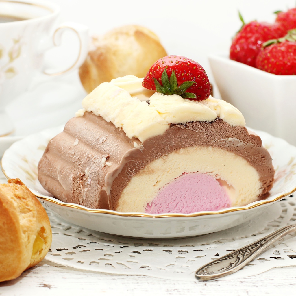 Аппетитное мороженое на столе с эклером и ягодами клубники 