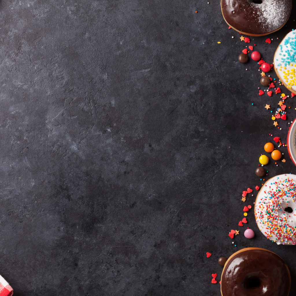 Аппетитные сладкие пончики с кофе на сером фоне