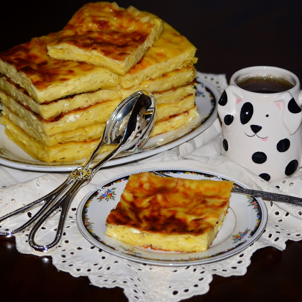 Аппетитный сладкий пирог с чашкой чая на столе