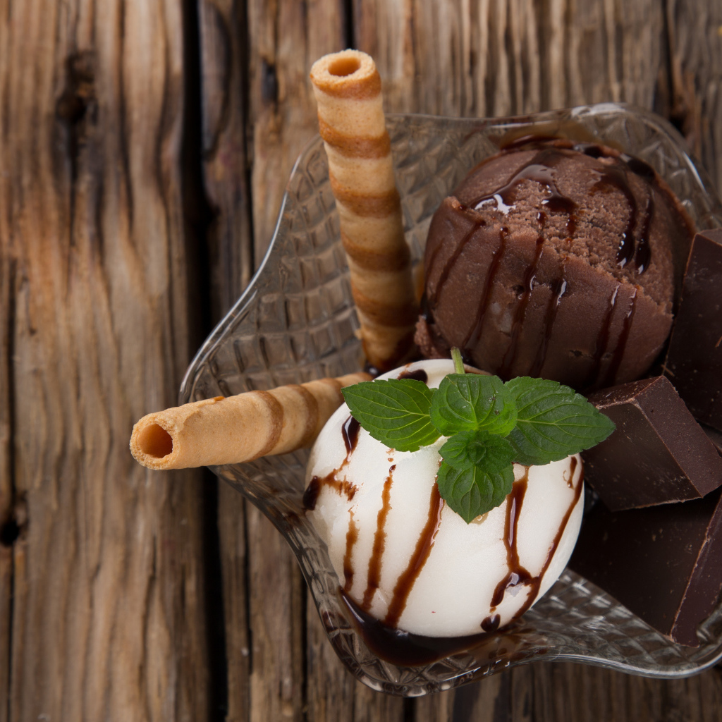 Шарик сливочного и шоколадного мороженого в пиале с трубочками