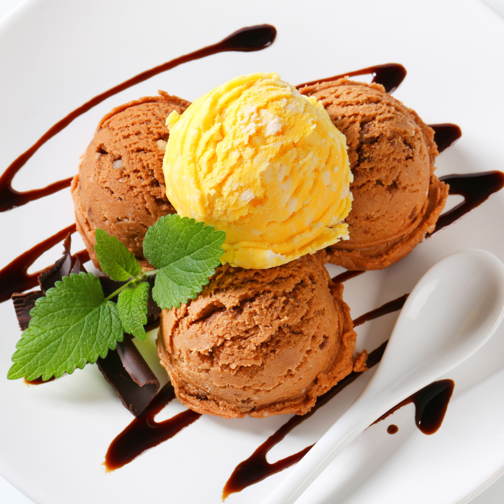 Шарики кофейного и фруктового мороженого на белой тарелке