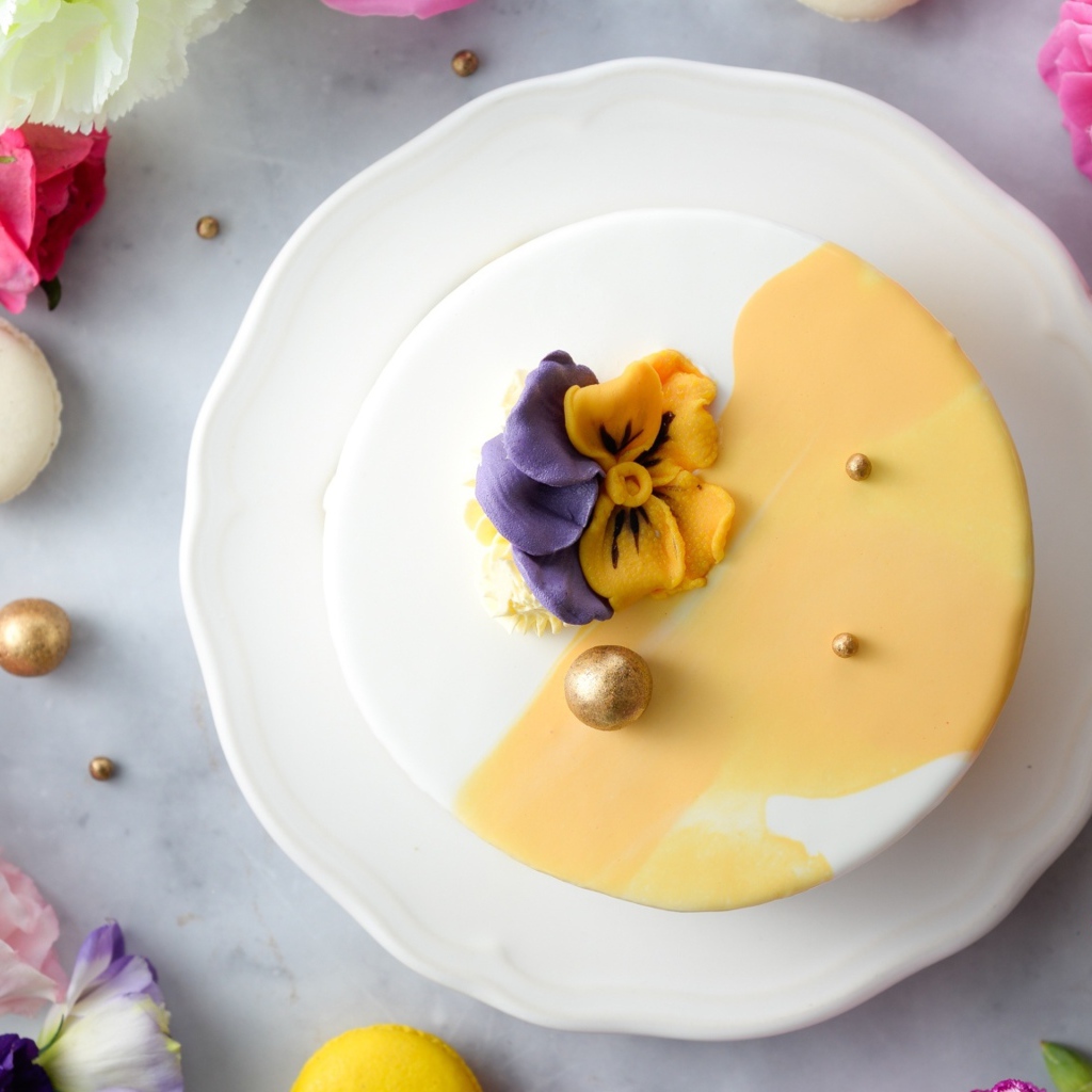 Красивый торт на белой тарелке с цветами вид сверху 