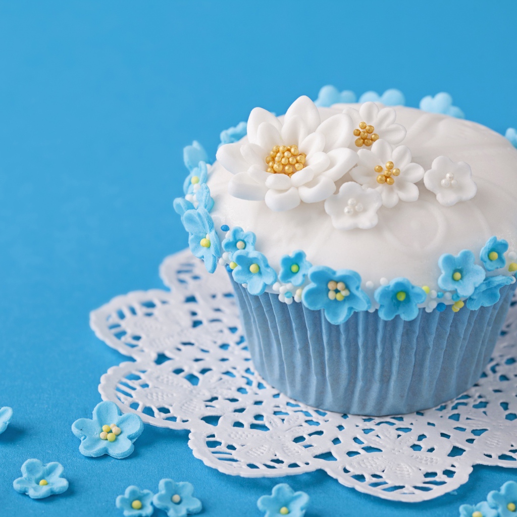Красивый кекс украшен сахарными цветами на голубом фоне