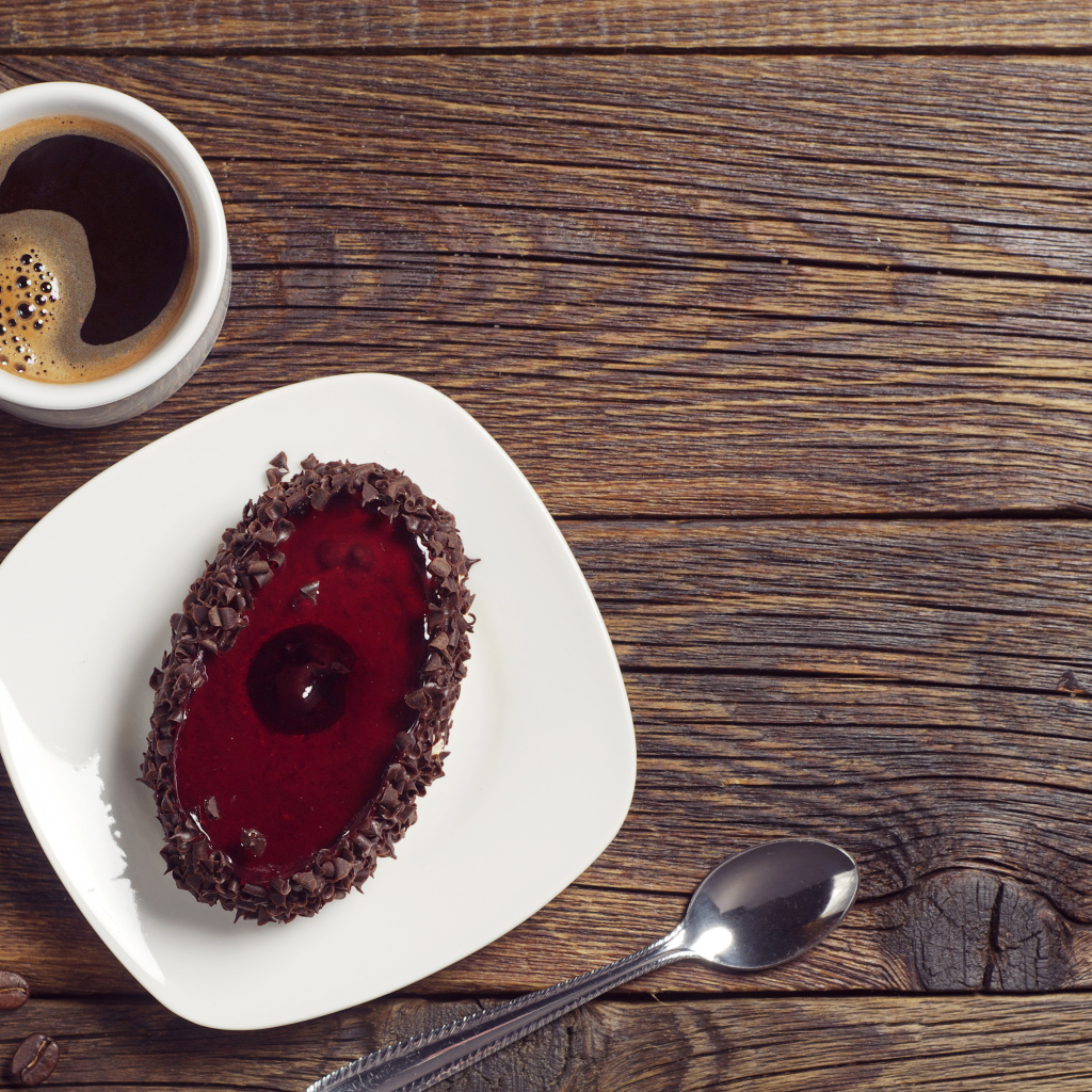 Пирожное с шоколадом на деревянном столе с чашкой кофе