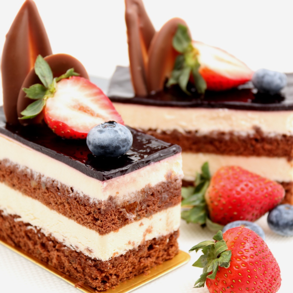 Пирожные с шоколадом, кремом и ягодами клубники и черники