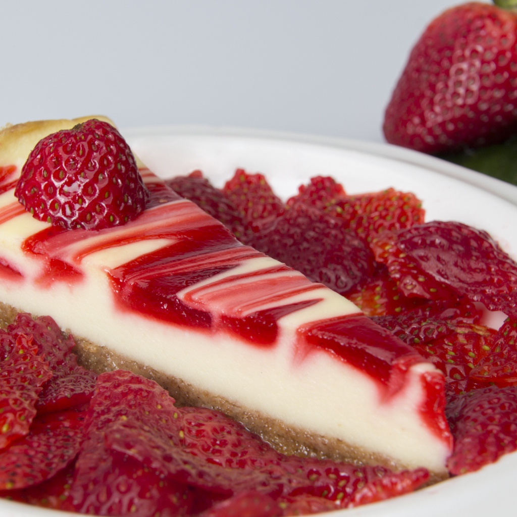 Чизкейк с ягодами клубники в белой тарелке 