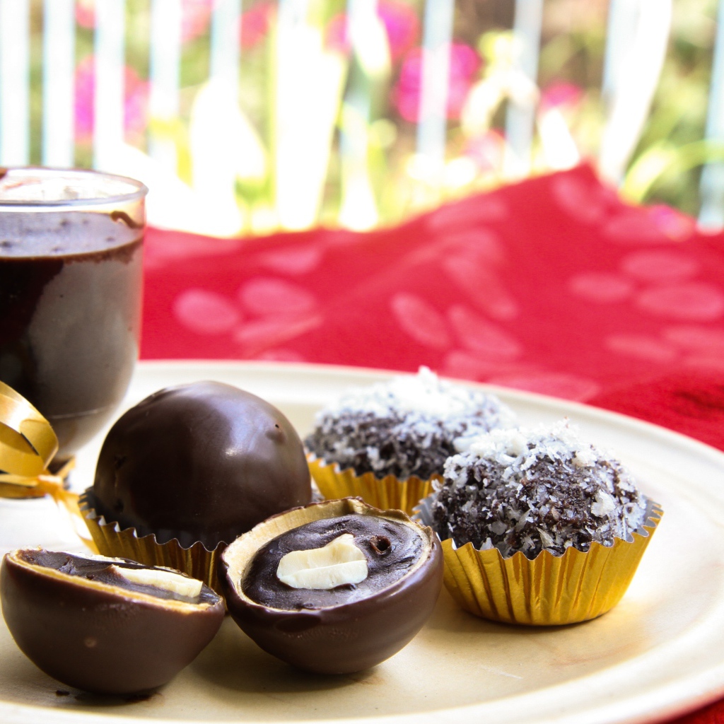 Шоколадные круглые конфеты на белой тарелке 