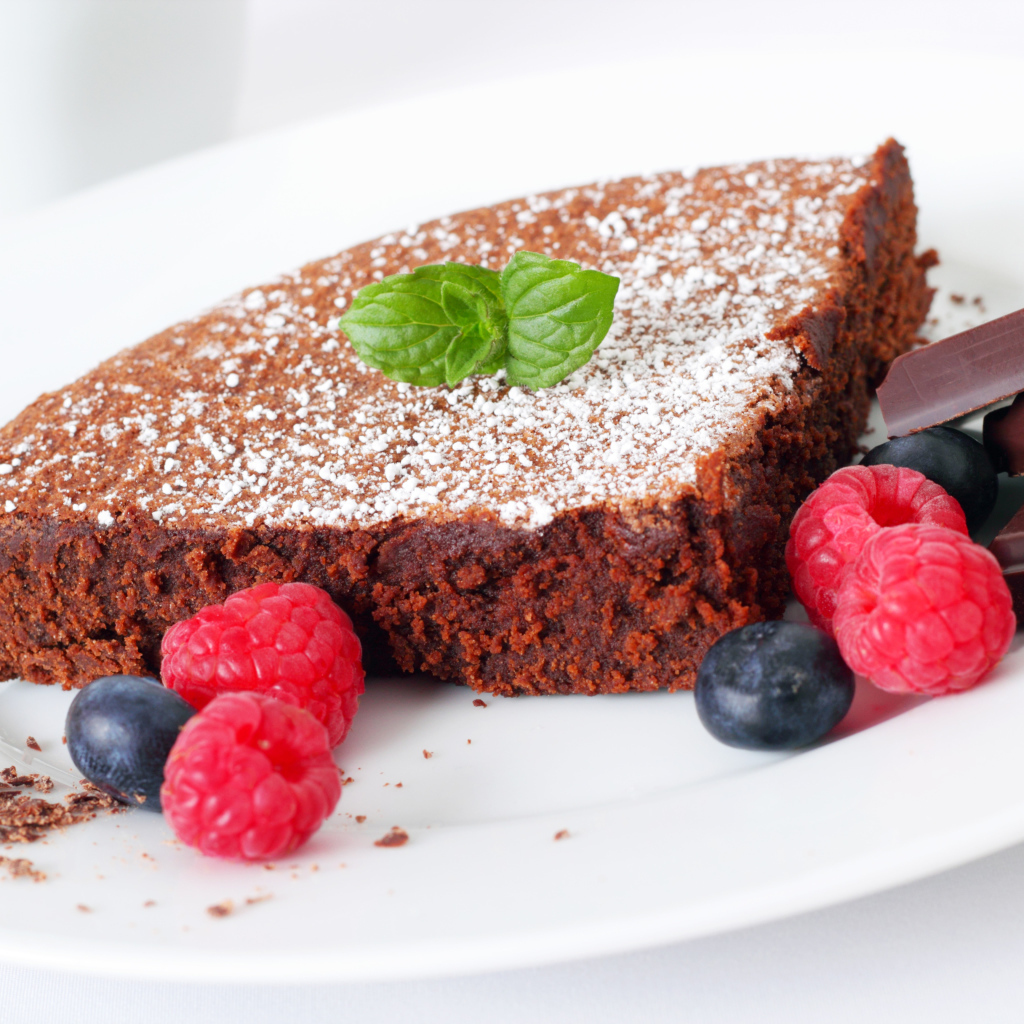 Шоколадный десерт брауни с ягодами малины и черники