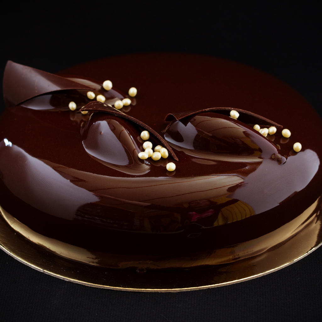 Шоколадный глянцевый торт на черном фоне 