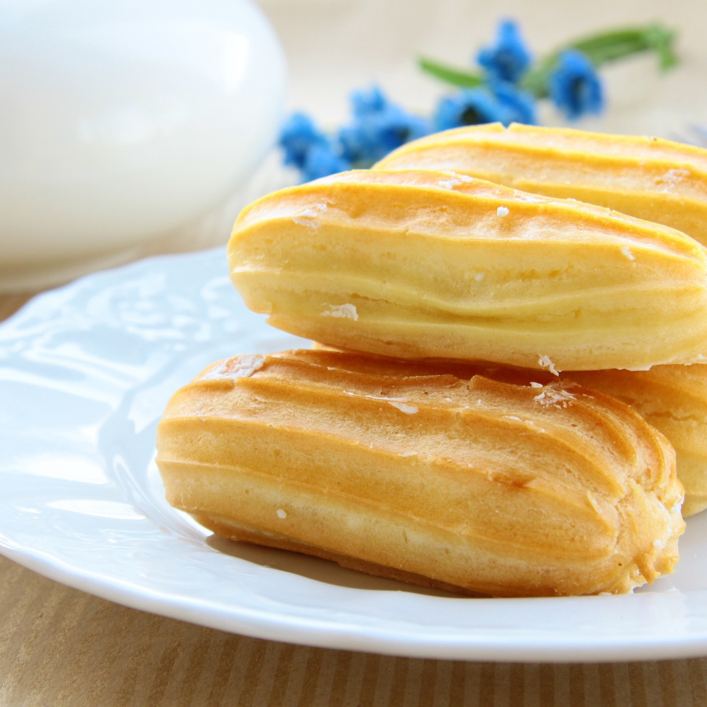 Заварные пирожные на большой белой тарелке 