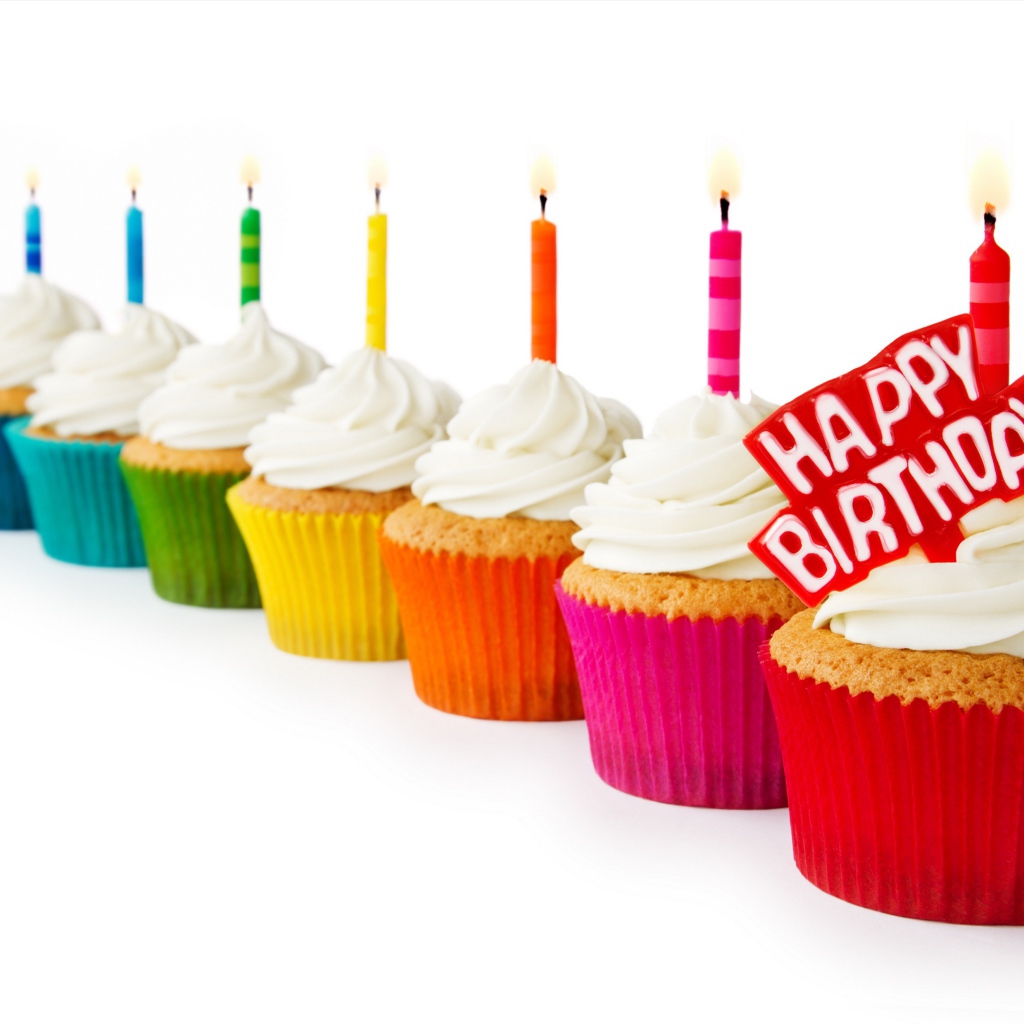 Cupcakes with candles and cream for birthday on a white background