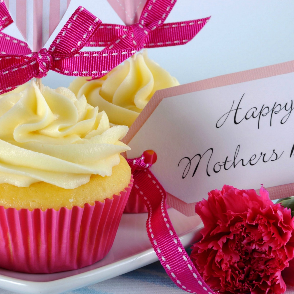 Кексы с кремом рядом с гвоздиками и пожеланиями к Дню матери