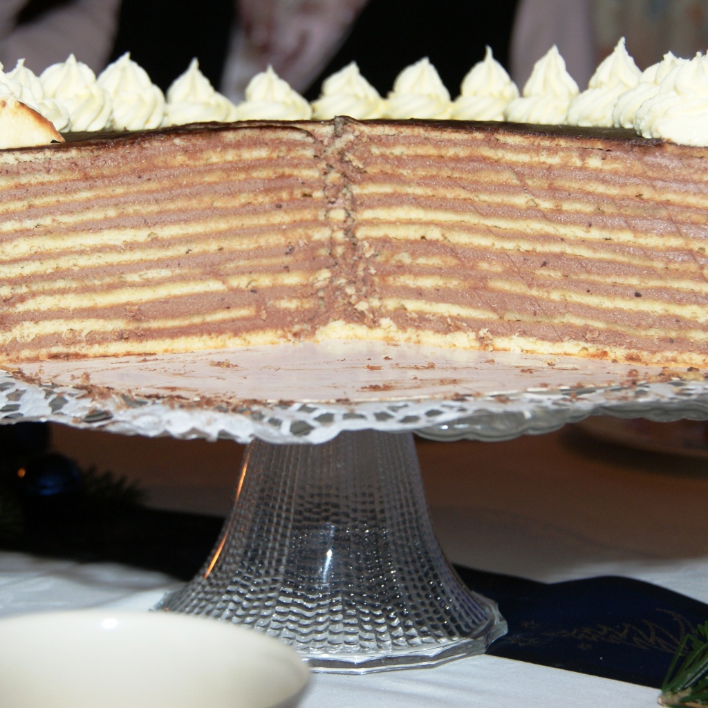 Разрезанный торт с кремом на стеклянном блюде