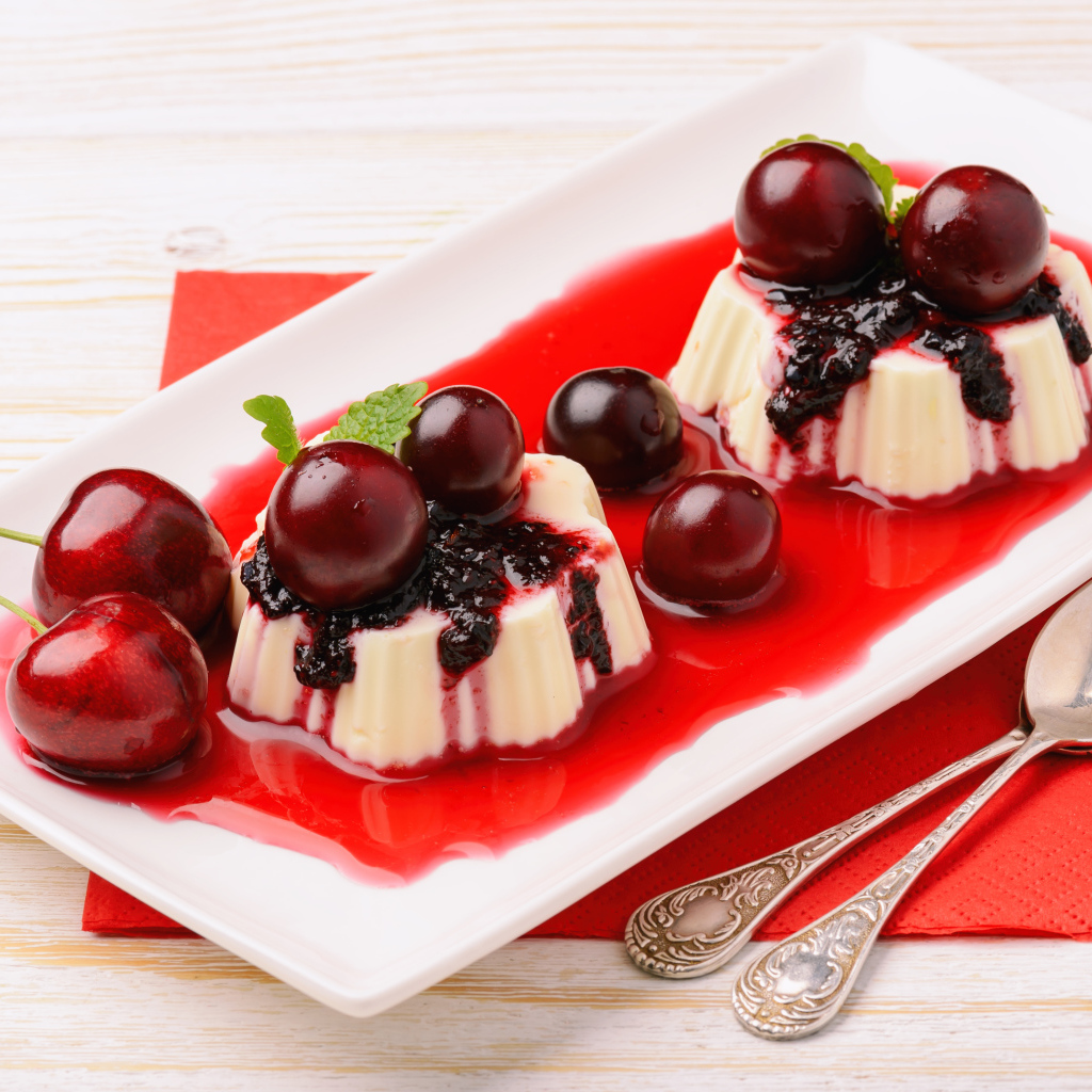 Десерт с желе и ягодами черешни на тарелке с сиропом