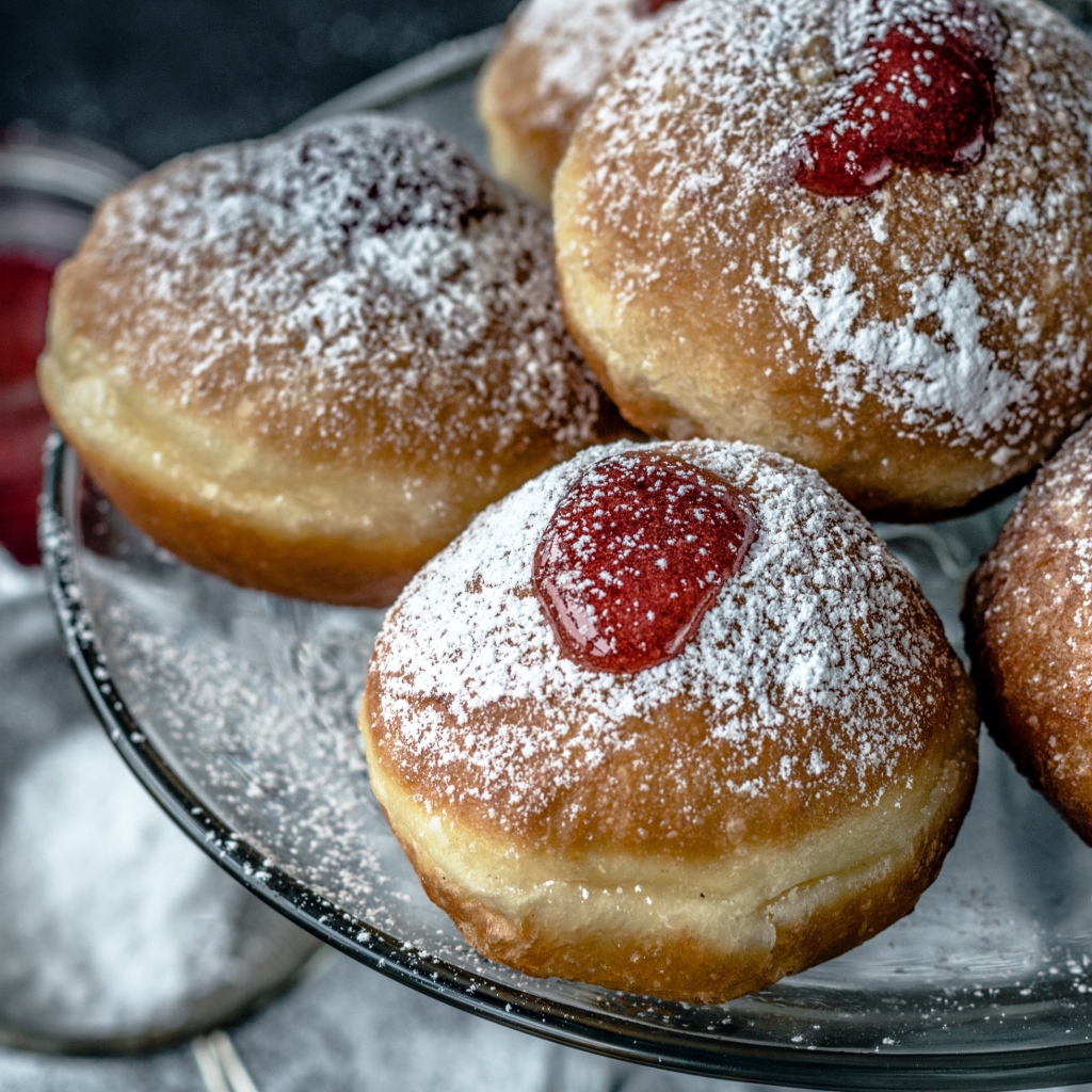 Пончики с вареньем и сахарной пудрой на блюде 