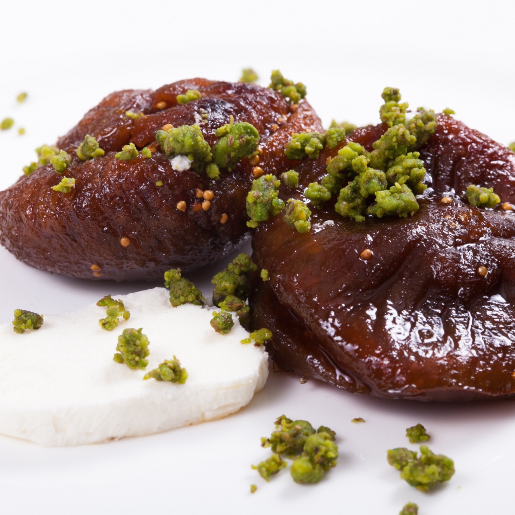 Инжир с фисташковыми орехами на белом фоне