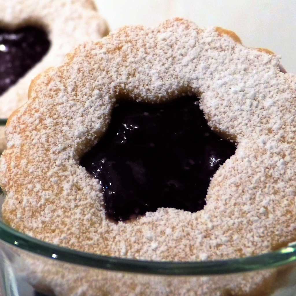 Фигурные печенья с джемом посыпанные сахарной пудрой 