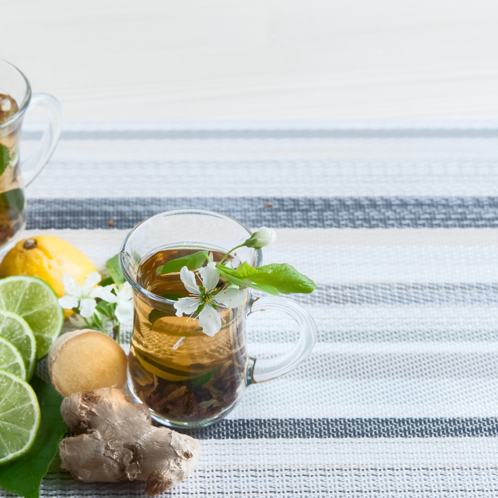 Стеклянные чашки с чаем на столе с имбирем и лаймом