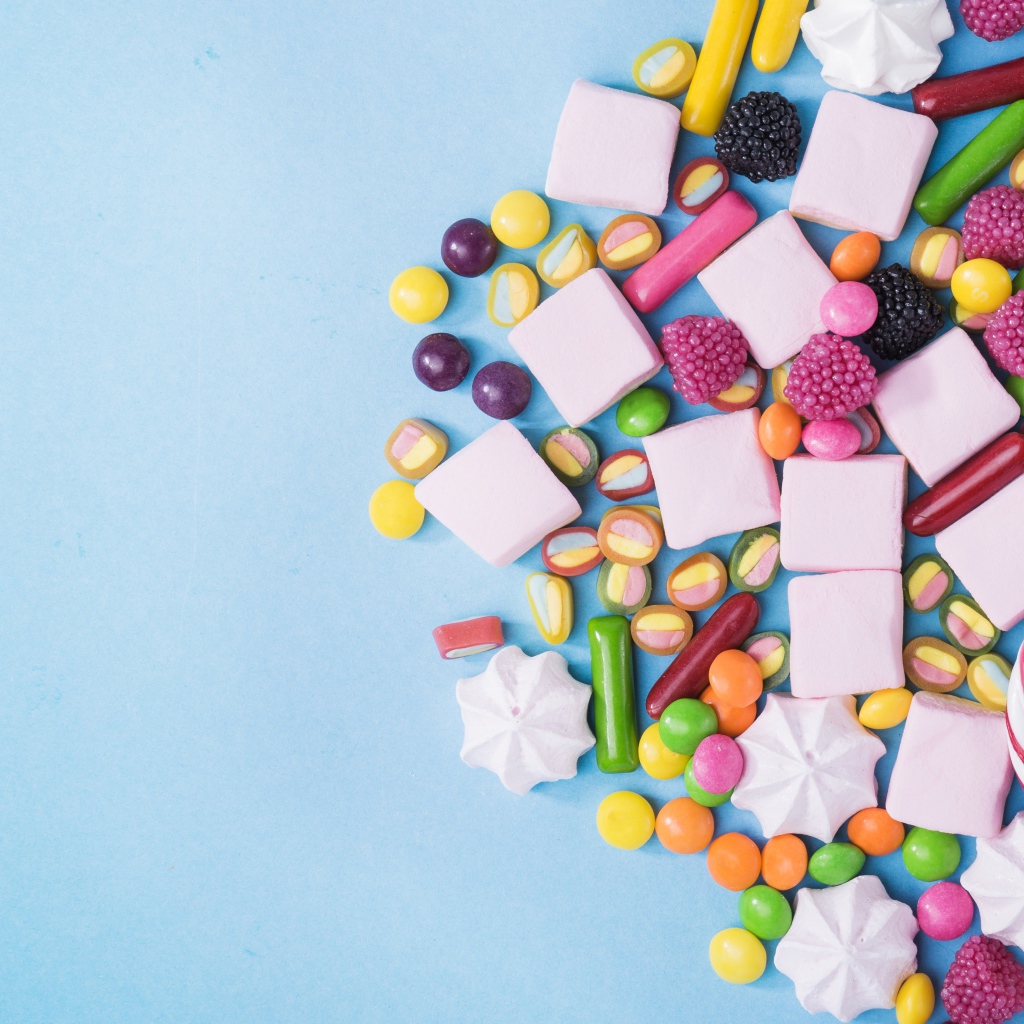 Маршмеллоу, конфеты и желе на голубом фоне